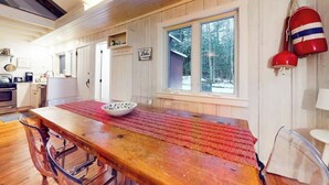 En inredning med träpanel, ett matbord, stolar, ett fönster och en röd boj som dekoration.