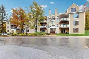 A multi-story residential building with balconies, a central entrance, and a driveway. - Ski-in/ski-out condo w/ deck, wood-burning fireplace, wifi, community amenities (West Dover)
