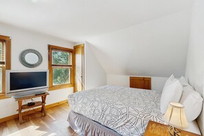 A bedroom with a bed, a television, a window, and a lamp. - Dog-friendly, lakeside home w/private dock/deck/free WiFi (Eden)