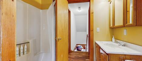 A bathroom with a bathtub, a sink, and a mirror.