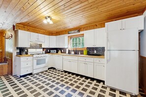 A kitchen with wooden cabinets, a stove, a dishwasher, and a refrigerator. - Dog-friendly, lakeside home w/private dock/deck/free WiFi (Eden)