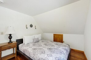 A bedroom with a bed, a nightstand, a lamp, and a wooden wardrobe. - Lake Eden home with private dock, gas fireplace, kayaks and firepit (Eden)