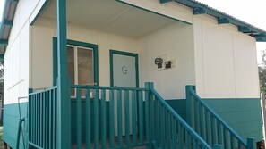 A building with a porch, a door labeled 'G', and a small wall-mounted device. - Australind Holiday Park (Australind)