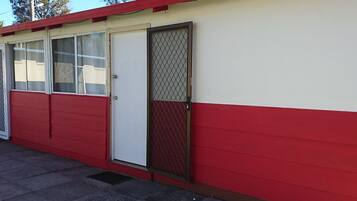 A red and white building with a closed door and windows.