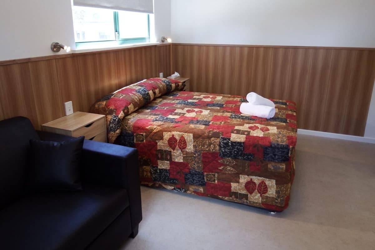 Departamento estándar | Tabla de planchar con plancha y ropa de cama