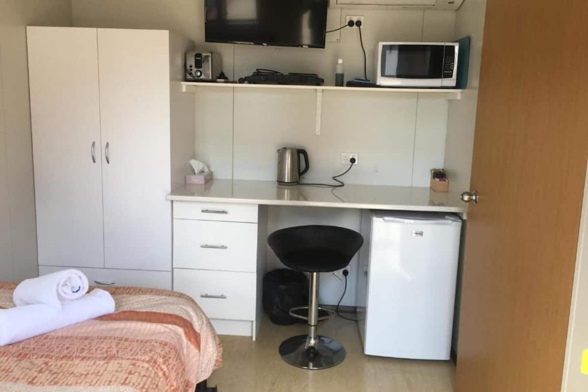 Departamento económico | Tabla de planchar con plancha y ropa de cama