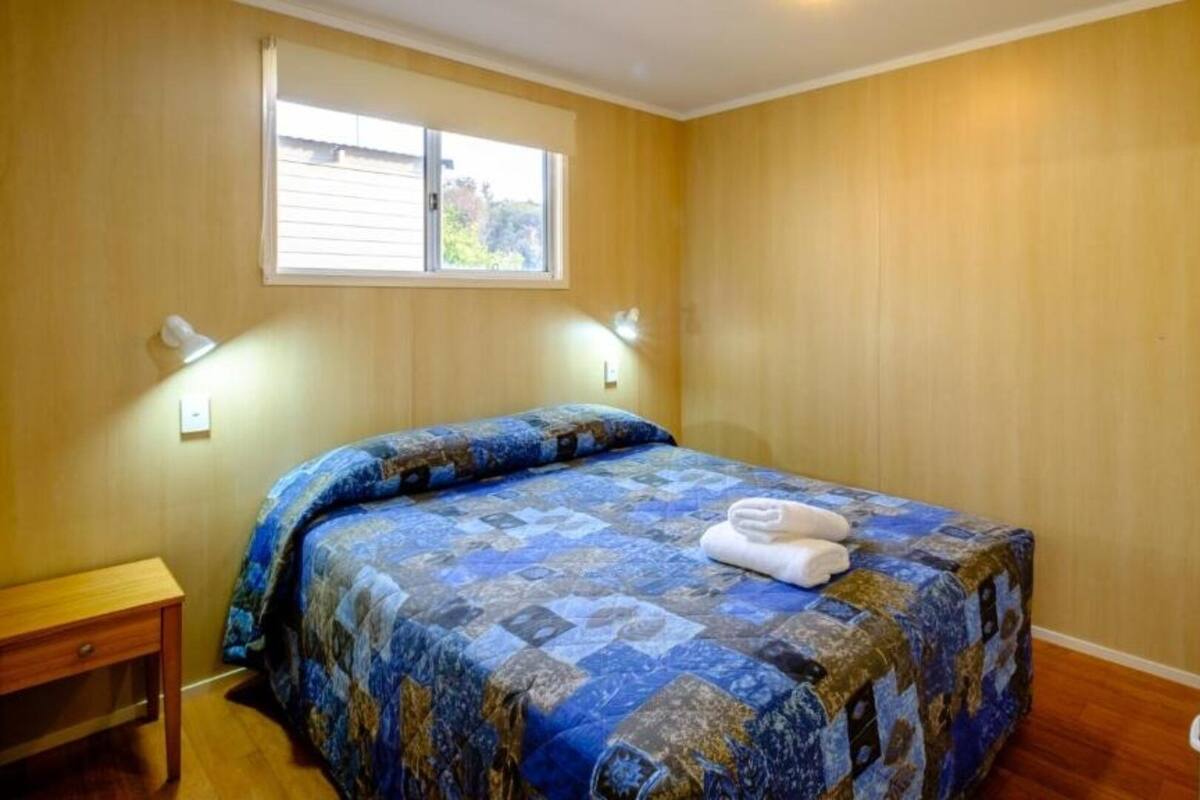 Departamento estándar, vista al jardín | Tabla de planchar con plancha y ropa de cama