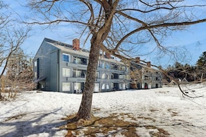 Ein mehrgeschossiges Wohngebäude mit moderner Architektur, das ein Flachdach und große Fenster aufweist.