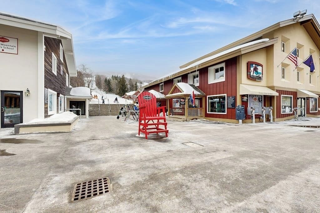 A building with a sign for Mountain's School, a red chair, and a flag.