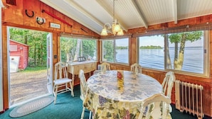 A room with a table, chairs, a radiator, and large windows overlooking a body of water. - Dog-Friendly Lakefront Home with WiFi, Private Dock & Firepit (Grand Isle)