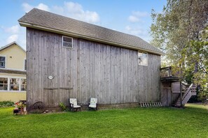 A wooden barn with a gabled roof, a small window, and a number '2356' on the side.