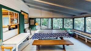 A room with a bed, a table, and chairs, large windows, and a view of trees. - Dog-Friendly Lakefront, w/Free WiFi, Patio, Deck/Dock, & Rustic Water Views (Charlotte)