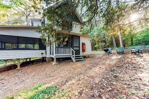 A cabin with a porch, a deck, and a small outdoor seating area. - Dog-Friendly Lakefront, w/Free WiFi, Patio, Deck/Dock, & Rustic Water Views (Charlotte)