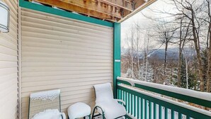 A covered porch with a view of snow-covered trees and mountains. - Spacious Mountain Retreat at Smugglers' Notch Resort w/ Great Views, Pool Access (Jeffersonville)