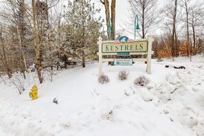 Schneebedeckte Landschaft mit einem Schild für Kestrels Woods am North Hill und einem gelben Feuerhydrant.