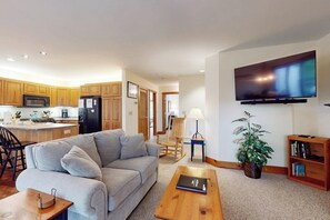 A modern kitchen with wooden cabinets, a built-in microwave, and a refrigerator.