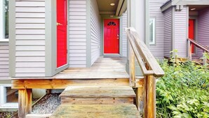 A wooden staircase leading to a red door, surrounded by a building with light-colored siding. - Inviting ski-in/ski-out condo - free WiFi, gas fireplace & free ski shuttle (Jay)