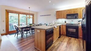 A kitchen with wooden cabinets, a microwave, a stove, and a dishwasher. - Inviting ski-in/ski-out condo - free WiFi, gas fireplace & free ski shuttle (Jay)