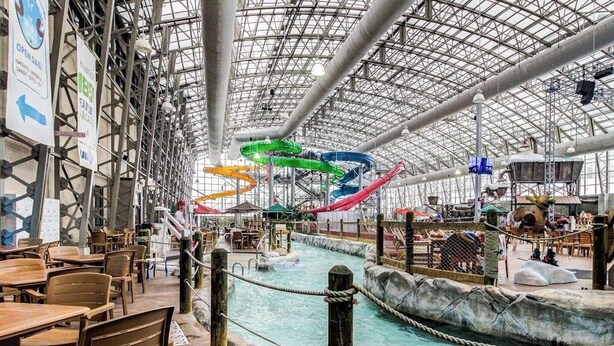 Un parco acquatico al coperto con scivoli, una piscina e un’area ristorazione.