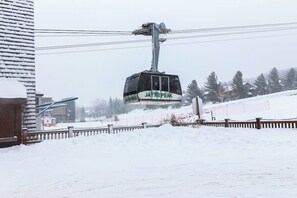 A cable car labeled 'Jay Peak' suspended above a snowy landscape.