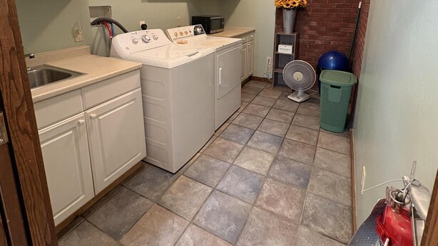 A compact kitchen with white cabinets, a microwave, a stove, and a fan. - Charming two-story duplex with a full kitchen & grassy yard - near Mallets Bay (Colchester)