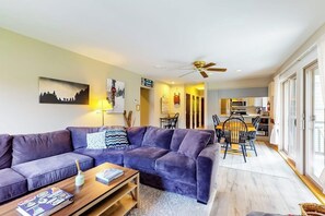 Ein Wohnzimmer mit einer Couch, einem Couchtisch und einem Essbereich mit Stühlen und einem Tisch.