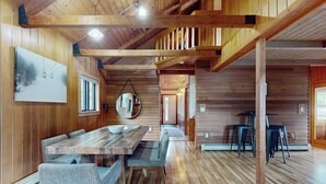 Un intérieur en bois comprenant un coin repas, un miroir et un escalier.