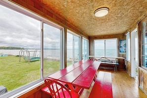 A room with large windows, a wooden ceiling, and a view of the sea. - Lakeside cottage w/ mountain views, canoes, firepit, enclosed porch, bbq, beach (Colchester)