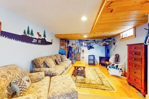 Ein gemütliches Wohnzimmer mit einer Couch, einem Sessel, einem kleinen Tisch und einer Wand mit einer Dekoration.