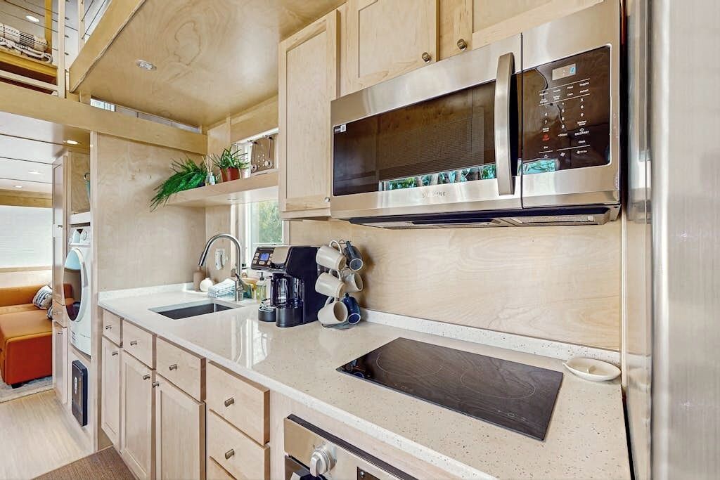 Cocina compacta con microondas, cafetera y lavabo.