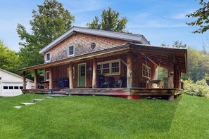 Ein zweistöckiges Holzhaus mit Veranda und Garage.