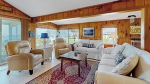 Un salon confortable avec un canapé, des fauteuils, une table basse et un tapis.