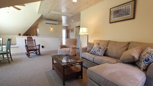 A cozy living room with a sofa, a wooden coffee table, and a chair.