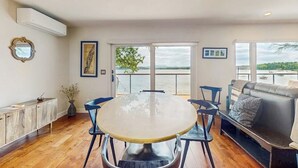 Un espace repas comprenant une table ronde, des chaises, un canapé et une vue sur l’extérieur.