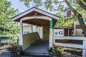 A covered entrance to a building with a sign indicating '109' and 'MOUNTAININSIDE RESORT AT STOWE.' - Tranquil Retreat with Shared Pool, Hot Tub, and Private Deck - Close to Skiing (Stowe)
