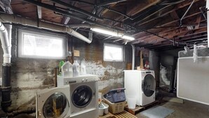 A laundry room with two washing machines, a dryer, and a window. - Cozy, Dog-Friendly Home w/ a Large Yard plus Free WiFi & a Private Washer/Dryer (Stowe)