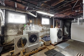 A laundry room with two washing machines, a dryer, and a window. - Cozy, Dog-Friendly Home w/ a Large Yard plus Free WiFi & a Private Washer/Dryer (Stowe)
