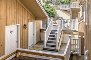 Un bâtiment en bois avec un escalier menant à une terrasse.