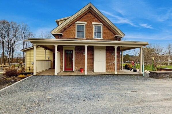 A two-story brick house with a covered porch and a garage.
