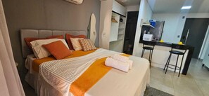 A hotel room with a bed, a desk, and a chair. - Fully furnished apartment in João Pessoa, very close to the beach, with leisure area and garage. (João Pessoa)