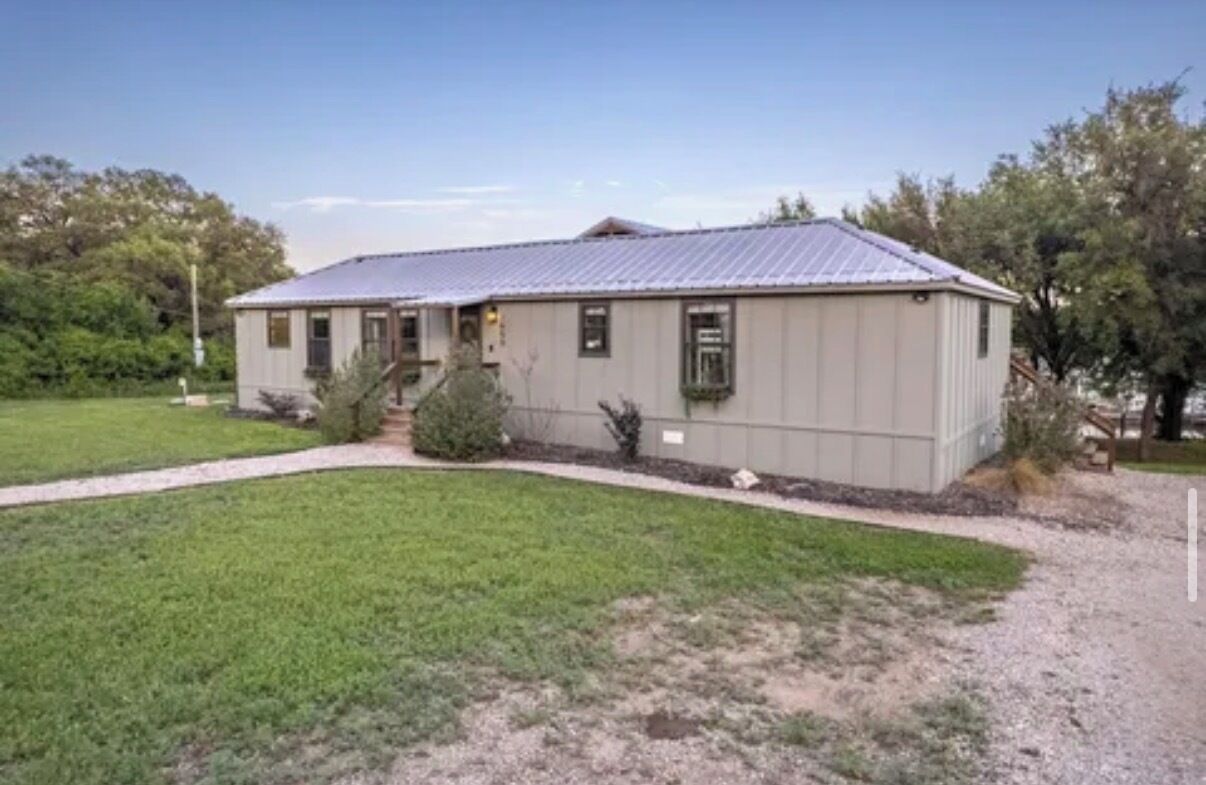 A single-story building with a metal roof, a front entrance, and a small porch.