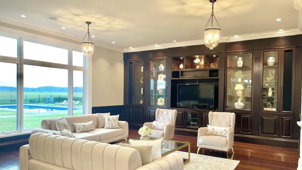 A spacious living room with a large sofa, armchairs, a coffee table, a TV, and a cabinet with glass doors. - 7,000 sqft Luxury Countryside Mansion on 1 acre estate lot, swimming pool 12 par (York)