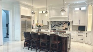 A spacious kitchen with white cabinetry, a marble island, and pendant lighting. - 7,000 sqft Luxury Countryside Mansion on 1 acre estate lot, swimming pool 12 par (York)