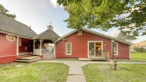 A red wooden house with a porch, a small attached structure, and a pathway leading to the entrance. - Adorable Getaway w/ Free WiFi, Full Kitchen, & Two Decks (Stowe)