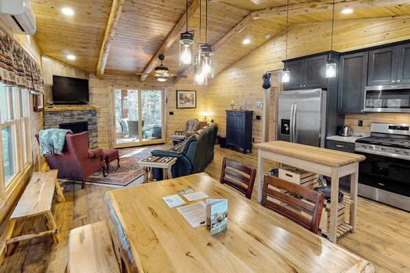L’intérieur d’un chalet en bois comprend un coin repas, une cuisine et un espace salon.