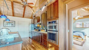 A modern kitchen with wooden cabinets, stainless steel appliances, and a wooden ceiling. - Private mountain retreat with a game room, home theater, & jetted tub (Underhill)