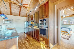 A modern kitchen with wooden cabinets, stainless steel appliances, and a wooden ceiling. - Private mountain retreat with a game room, home theater, & jetted tub (Underhill)