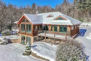 A cabin with a balcony, large windows, and a snow-covered landscape. - Private mountain retreat with a game room, home theater, & jetted tub (Underhill)