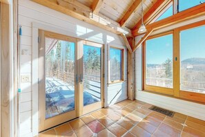 A room with wooden beams, large windows, and a view of a snowy landscape. - Private mountain retreat with a game room, home theater, & jetted tub (Underhill)