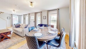 A dining area with a round table set for four, surrounded by chairs.